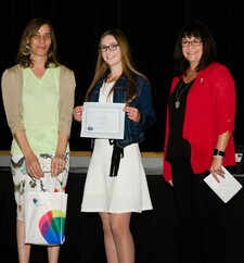 NGPS Trustee Anita Portsmouth (left) and NGPS Assistant Superintendent Leslee Jodry (right) present Fox Creek high school student, Sarah Norman with the NGPS Award High School!
